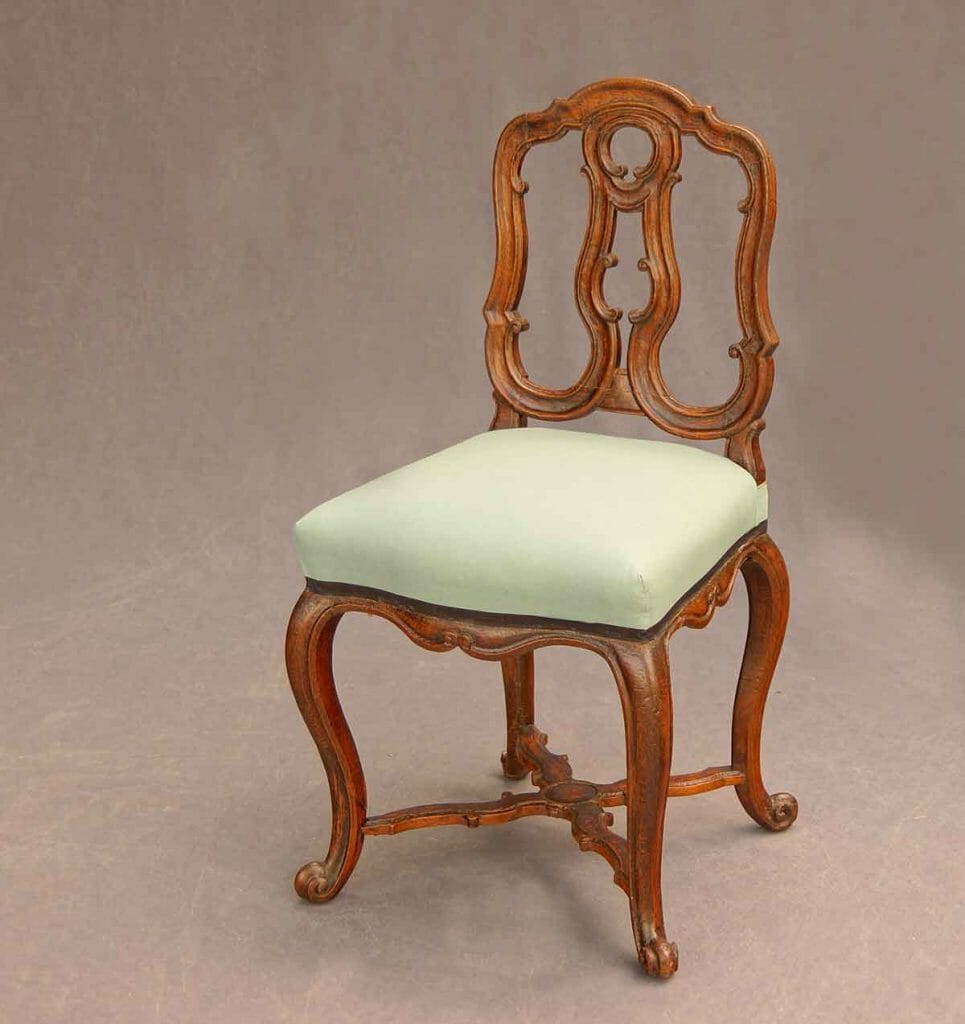 Das Bild zeigt einen geschnitzten Rokoko-Stuhl