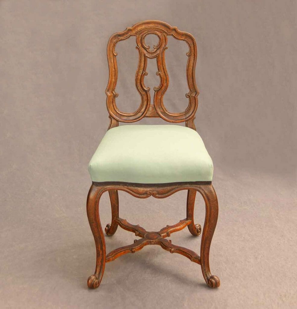Auf dem Bild ist ein reich geschnitzer Rokoko-Stuhl zu sehen