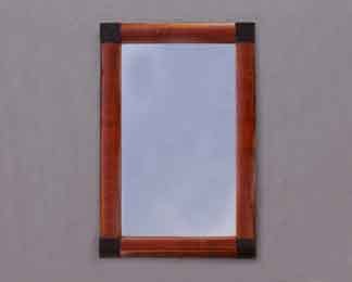 Auf dem Bild ist ein Biedermeier-Spiegel in Mahagoni zu sehen. Er hat schwarze Eckquadrate.