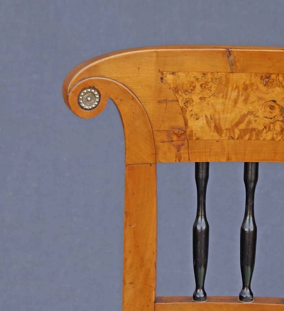 Auf dem Bild ist knapp die Hälfte einer Rückenlehne eines Stuhles zu sehen. Sie ist von einem Biedermeier-Stuhl der fast 200 Jahre alt ist. Dies ist einer von fünf gleichen Biedermeier-Stühlen aus dem Besitz der Herzöge von Württemberg.