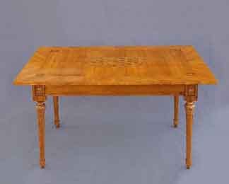 Ein antiker Louis-seize-Tisch aus Kirschbaumholz mit kunstvollen Marketerie-Einlagen auf der Tischplatte und kannelierten, spitz zulaufenden Beinen.