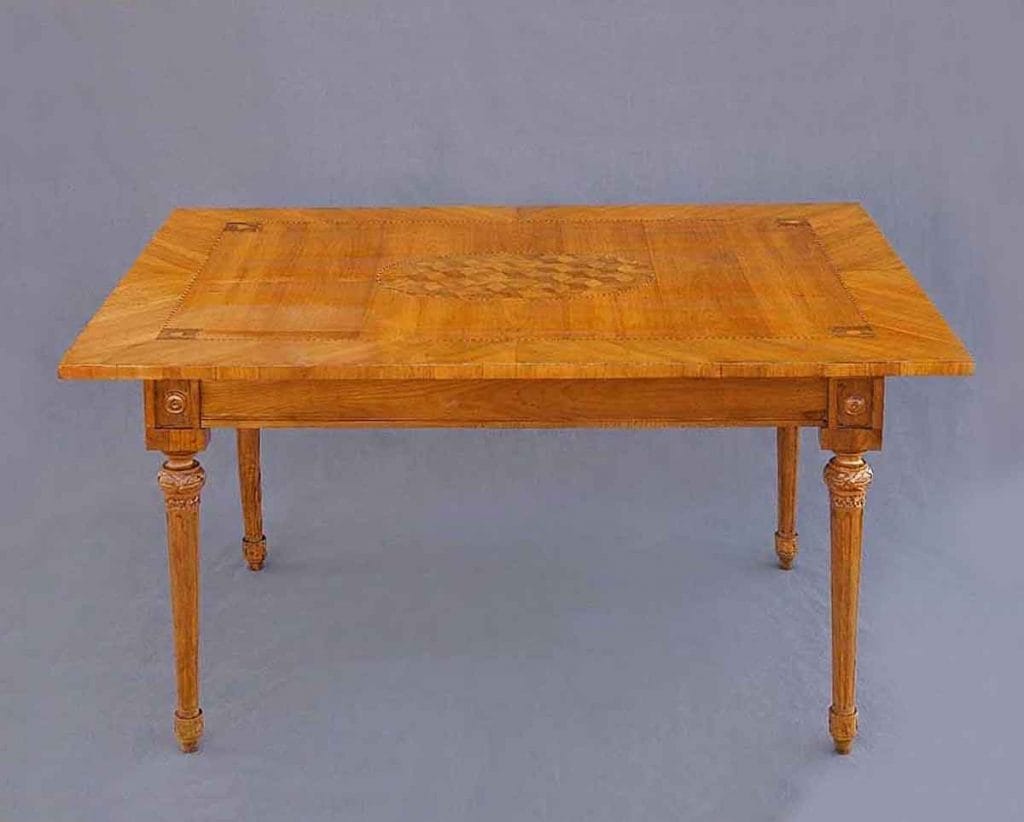 Louis Seize Tisch4 Ein antiker Louis-seize-Tisch aus Kirschbaumholz mit kunstvollen Marketerie-Einlagen auf der Tischplatte und kannelierten, spitz zulaufenden Beinen.