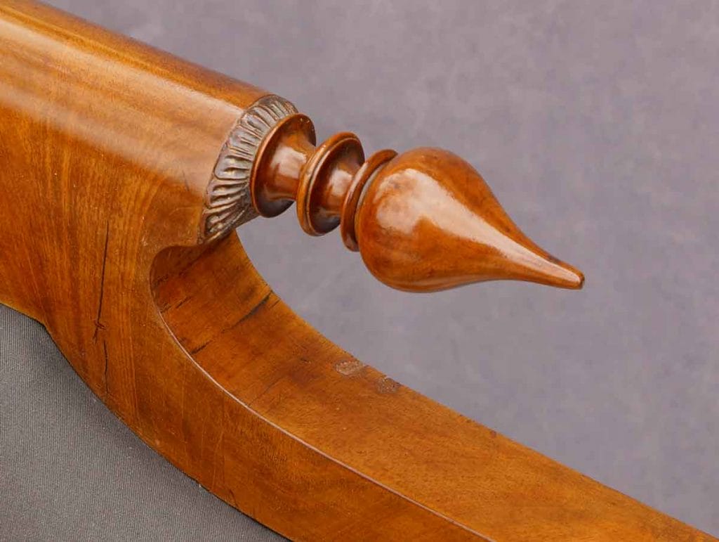Biedermeier Sofa Nordeutsch Detail1 Detaillierte Nahaufnahme des kunstvoll gedrechselten und geschnitzten Holzornaments an der oberen Kante des vorher gezeigten Biedermeier-Sofas.
