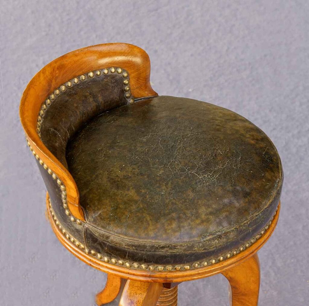 Biedermeier-Drehhocker1 Dunkelgrüner Lederbezug eines Drehockers aus der Biedermeierzeit