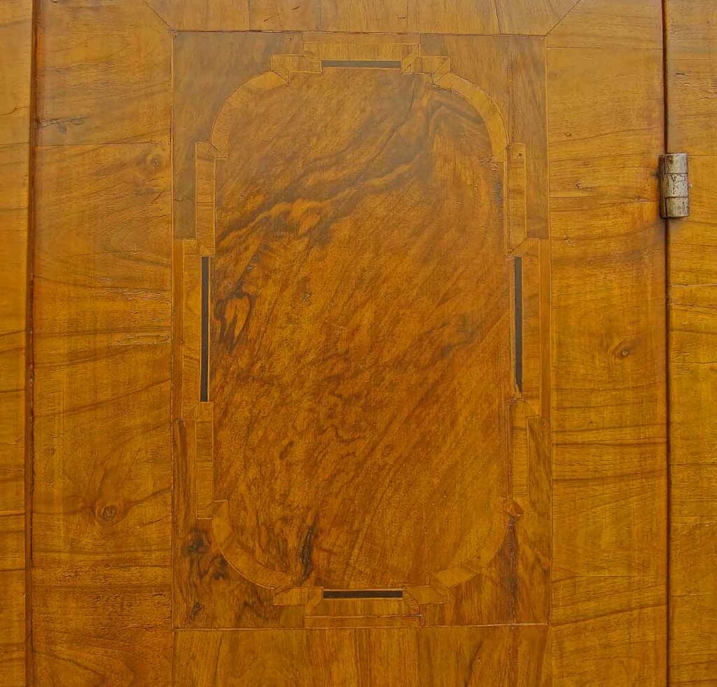 Barock-Schrank4 Detailaufnahme einer Türfüllung mit feiner Holz-Intarsie und Wurzelholzmaserung an einem echten Barockschrank.