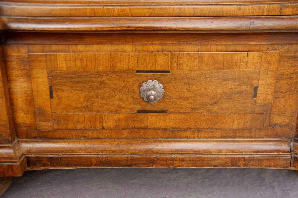 Barock-Schrank9 Detailansicht einer Schrank-Schublade aus der Barockzeit mit furnierter Frontseite, dunklen Ader-Einlagen und zentralem Knopf und Rosette aus Eisen.