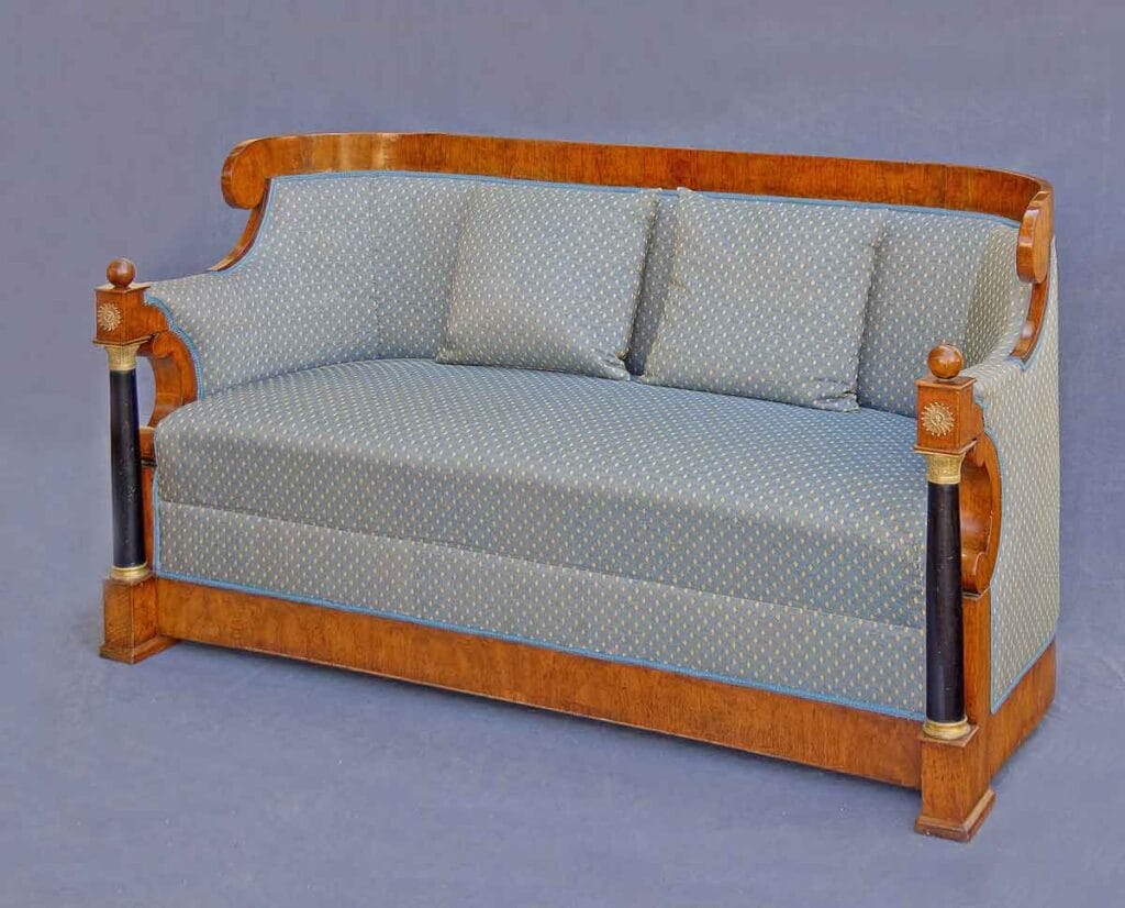 Biedermeier-Sofa Elegantes Biedermeier-Sofa aus Kirschbaumholz mit blauer, gemusterter Polsterung, zwei passenden Kissen und schmalen, schwarz-goldenen Säulen an den Armlehnen.