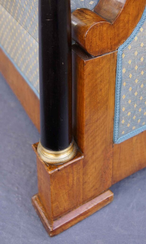 Biedermeier-Sofa3 ahaufnahme der unteren Fuß- und Säulenkonstruktion eines Biedermeier-Sofas aus Nussbaumholz mit schwarzer Ziersäule und Messingbasis.